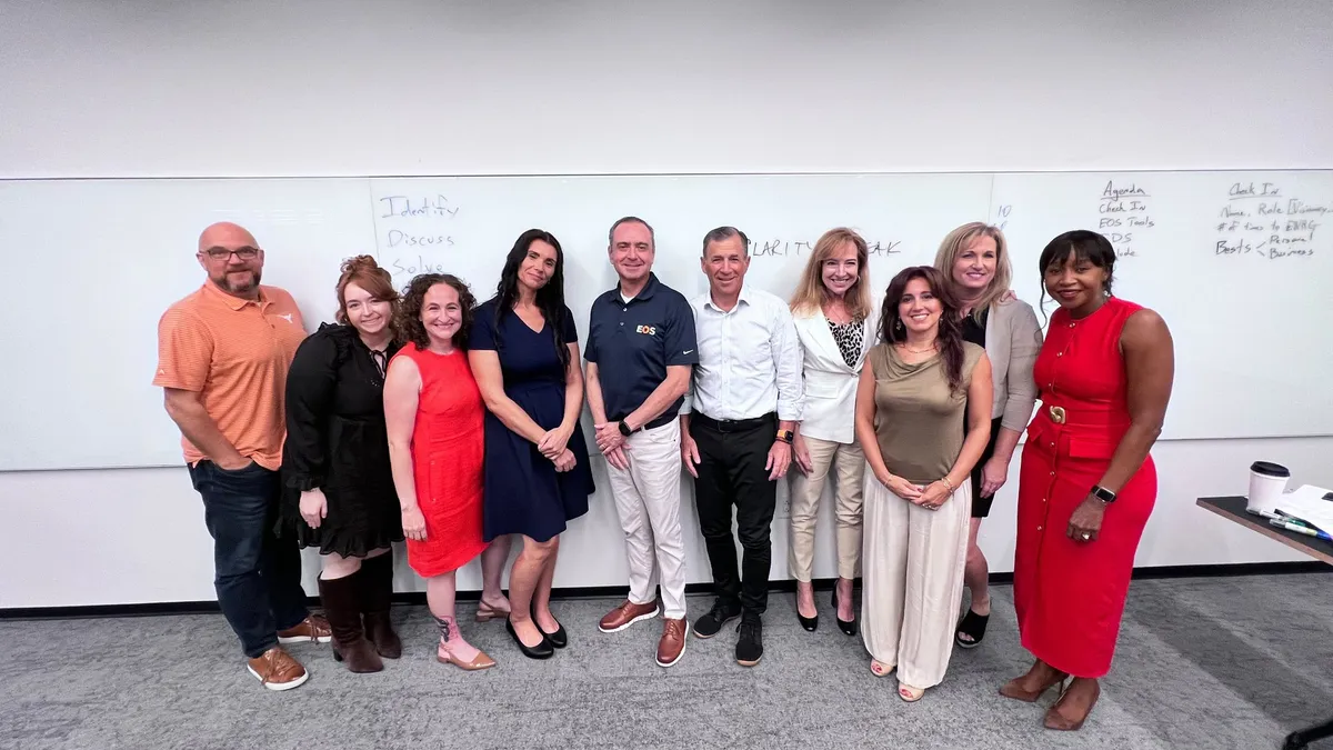 The ENRG HTX group at The Ion after the August 2026 Clarity Break session, standing at a whiteboard reading Identify, Discuss, Solve.